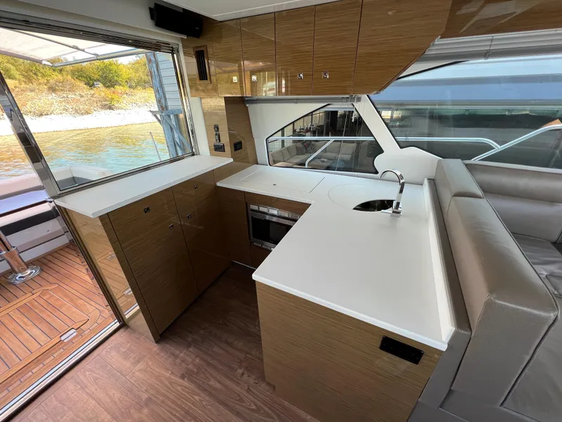Slide: The Image of Modern kitchen area in 2018 Cruisers Yachts 50 Cantius with sleek cabinetry and water view. - 19