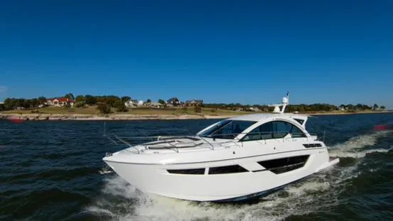 Slide: The Image of 2018 Cruisers Yachts 50 Cantius cruising on open water near shoreline. - 2