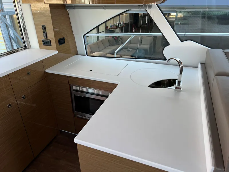 Slide: The Image of Modern kitchen area in a 2018 Cruisers Yachts 50 Cantius with sleek countertops and built-in appliances. - 21