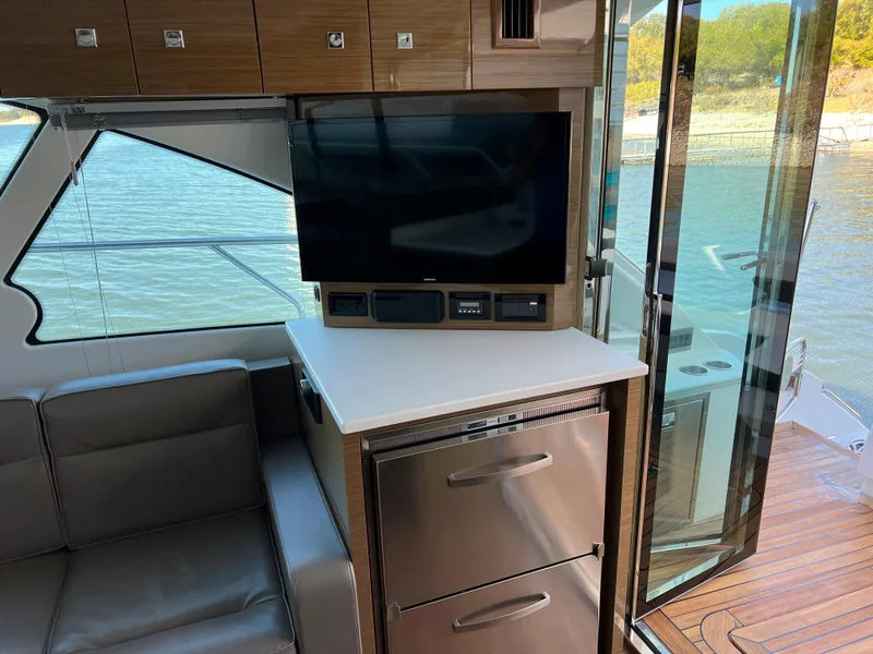 Slide: The Image of Interior of 2018 Cruisers Yachts 50 Cantius with TV, fridge, and seating. - 22