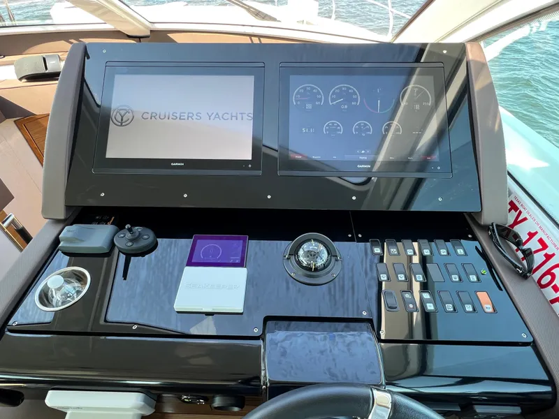 Slide: The Image of Control panel of a 2018 Cruisers Yachts 50 Cantius with dual screens and navigation instruments. - 25