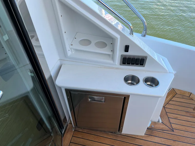 Slide: The Image of 2018 Cruisers Yachts 50 Cantius outdoor kitchenette with sink, storage, and cup holders. - 32