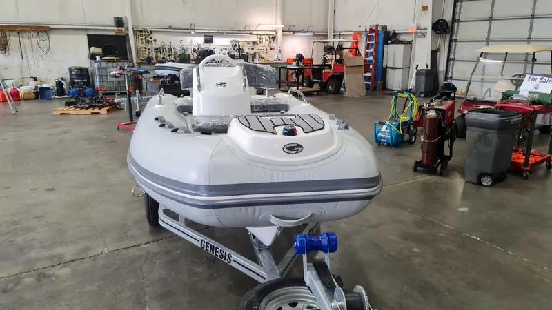 Slide: The Image of 2023 Grand Inflatables G380HLF boat on trailer in a workshop. - 2