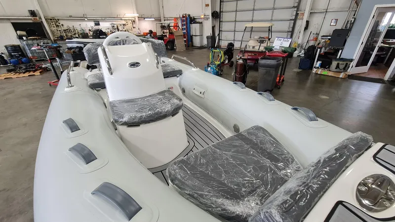 Slide: The Image of 2023 Grand Inflatables G380HLF boat in a workshop, covered in protective plastic. - 4