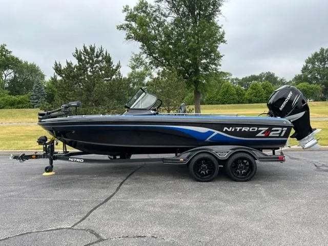 Slide: The Image of 2023 Nitro ZV21 Pro fishing boat on trailer in a park setting. - 0