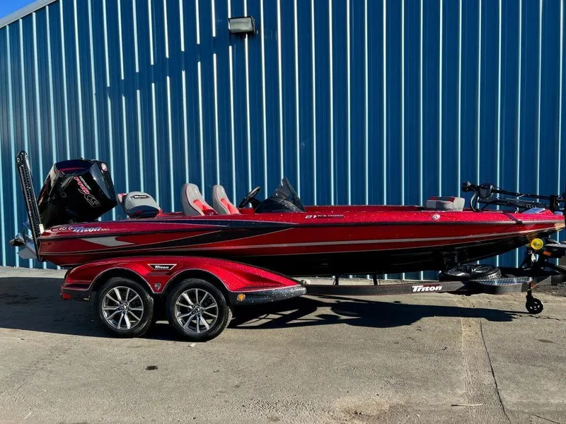 The Image of 2023 Triton 21 TrX Patriot bass boat in red on a trailer. - 1