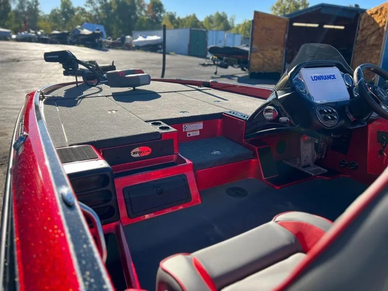 Slide: The Image of 2023 Triton 21 TrX Patriot boat interior with Lowrance electronics and red accents. - 8