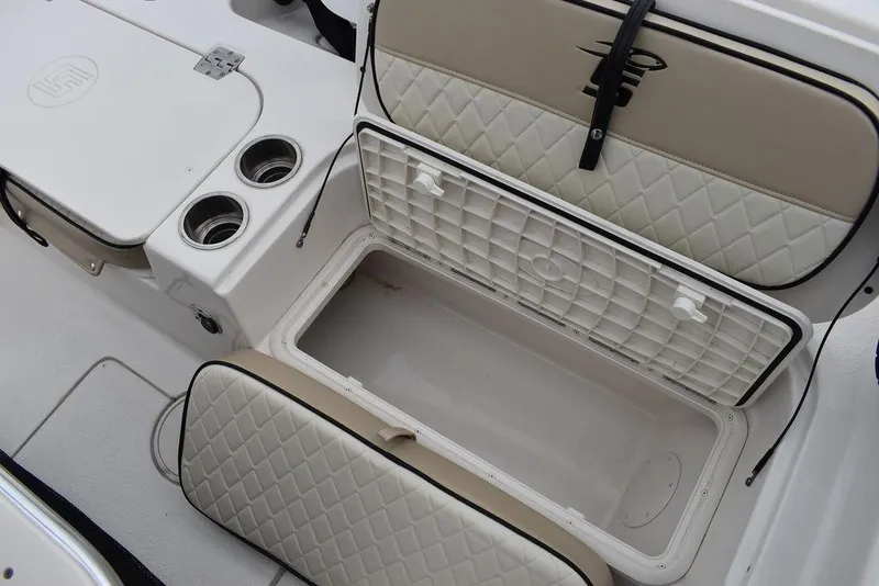 Slide: The Image of 2022 Carolina Skiff 19 Ultra Elite boat storage compartments with quilted seats and cup holders. - 16
