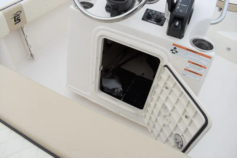 Slide: The Image of 2022 Carolina Skiff 19 Ultra Elite console storage compartment with open door. - 22