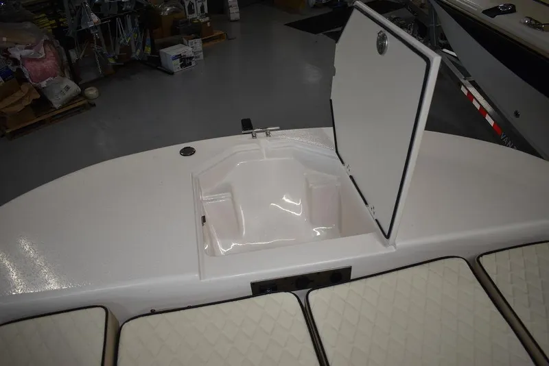Slide: The Image of 2023 Carolina Skiff 19 LS boat storage compartment with open hatch and cushioned seating. - 18