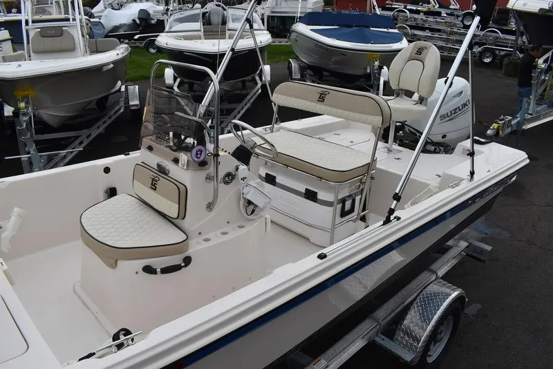 Slide: The Image of 2023 Carolina Skiff 178 JLS boat interior with seating and console, docked on a trailer. - 16