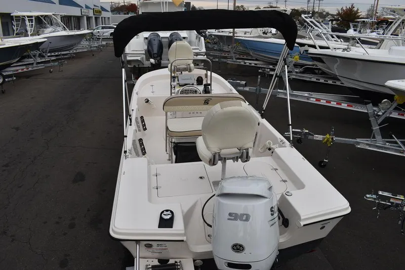 Slide: The Image of 2023 Carolina Skiff 178 JLS boat with Suzuki 90 outboard motor, docked at a marina. - 9
