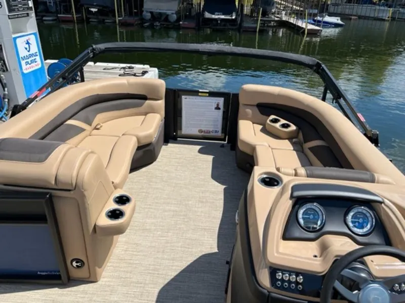 Slide: The Image of 2023 Barletta Cabrio 24 UE pontoon boat interior with tan seating and control panel. - 11