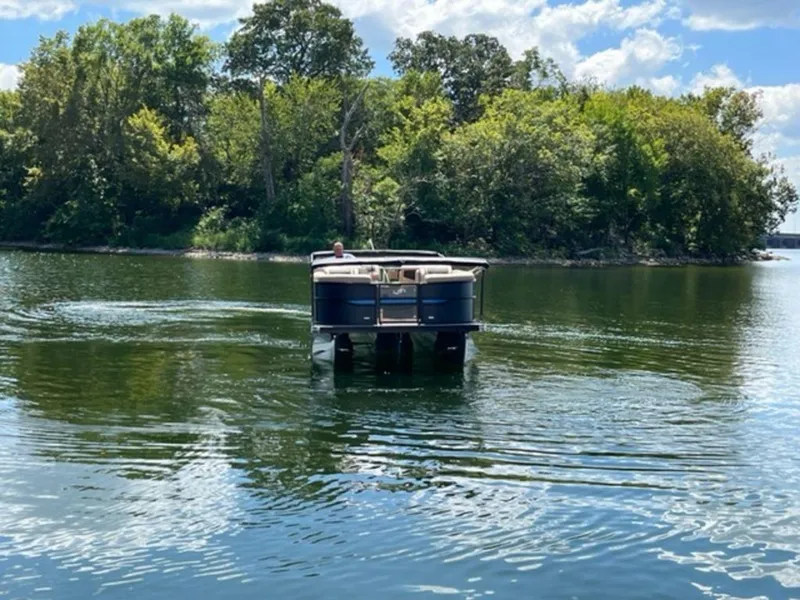 Slide: The Image of 2023 Barletta Cabrio 24 UE pontoon boat cruising on a scenic lake. - 20