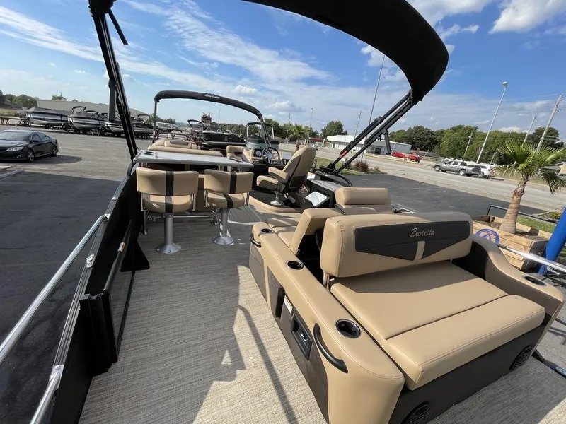 Slide: The Image of 2023 Barletta Cabrio 24 UE pontoon boat with tan seating and black canopy. - 24