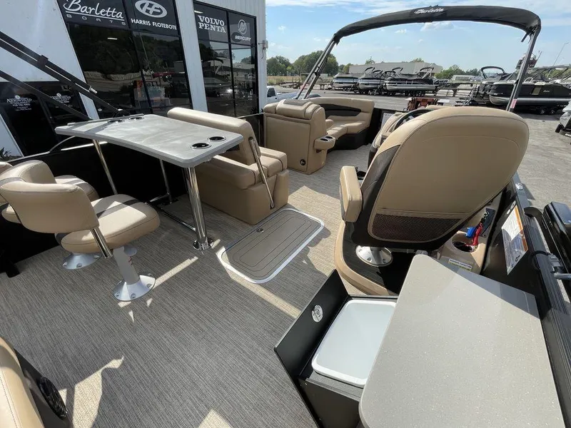 Slide: The Image of 2023 Barletta Cabrio 24 UE pontoon boat interior with beige seating and table. - 27