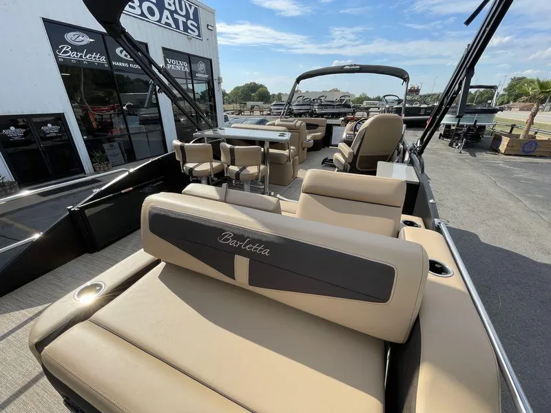 Slide: The Image of 2023 Barletta Cabrio 24 UE pontoon boat with beige seating at a dealership. - 30