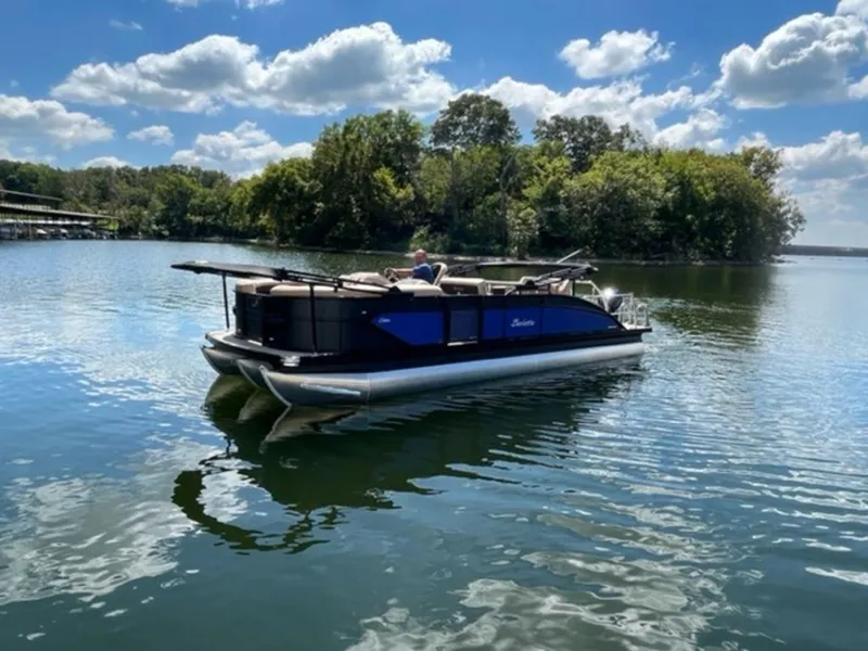 Slide: The Image of 2023 Barletta Cabrio 24 UE pontoon boat on a serene lake with lush greenery. - 4