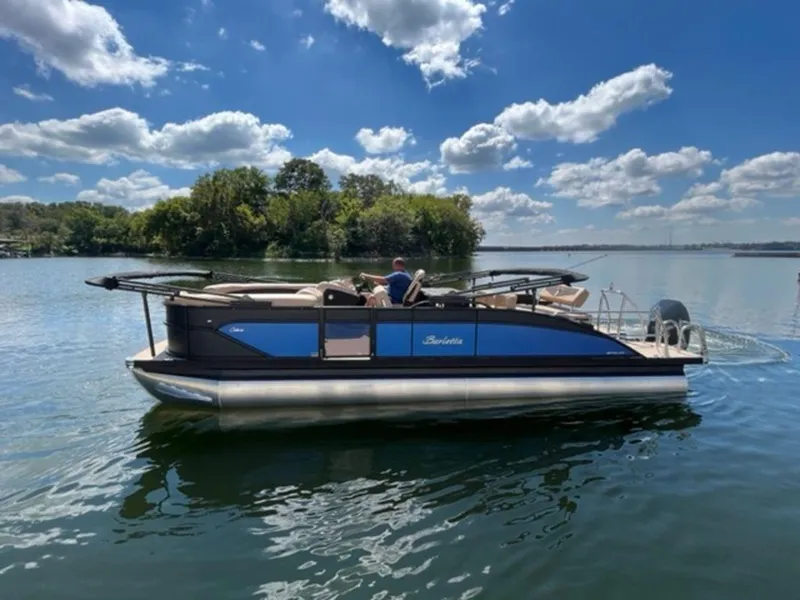 Slide: The Image of 2023 Barletta Cabrio 24 UE pontoon boat on a serene lake under a blue sky. - 7