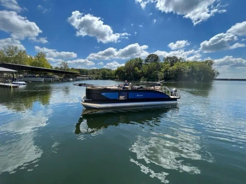 Slide: The Image of 2023 Barletta Cabrio 24 UE pontoon boat on a serene lake under a blue sky. - 8