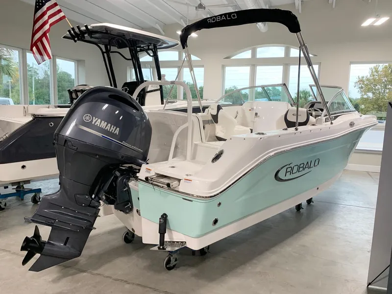 Slide: The Image of 2024 Robalo R207 Dual Console boat with Yamaha outboard motor in showroom. - 1