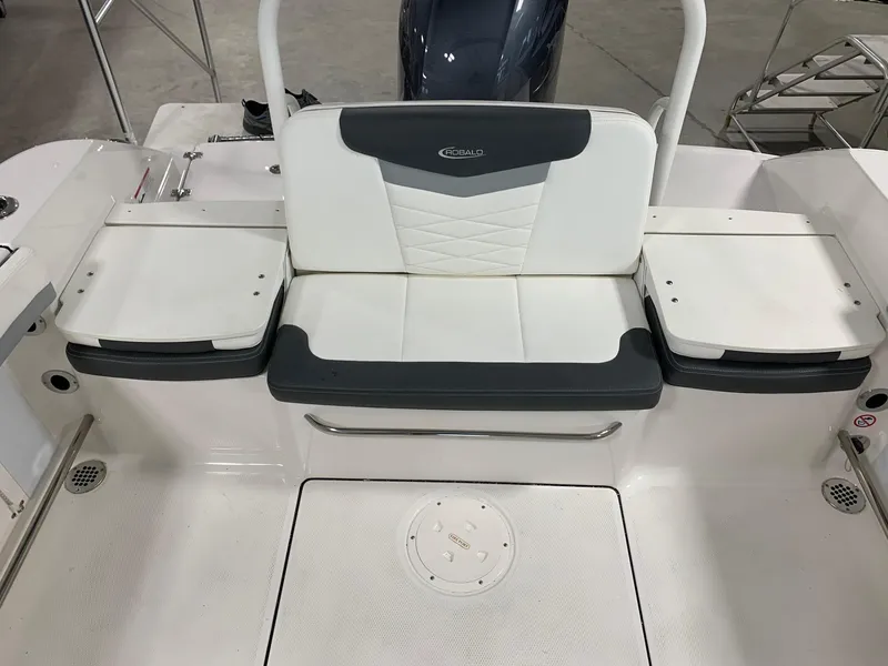 Slide: The Image of 2024 Robalo R207 Dual Console boat seating area with white and gray upholstery. - 11