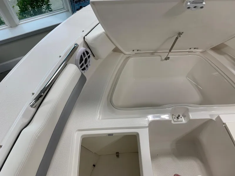 Slide: The Image of 2024 Robalo R207 Dual Console boat storage compartments and seating area. - 4