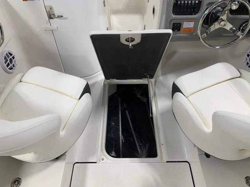 Slide: The Image of 2024 Robalo R207 Dual Console interior with open storage compartment and white seating. - 10