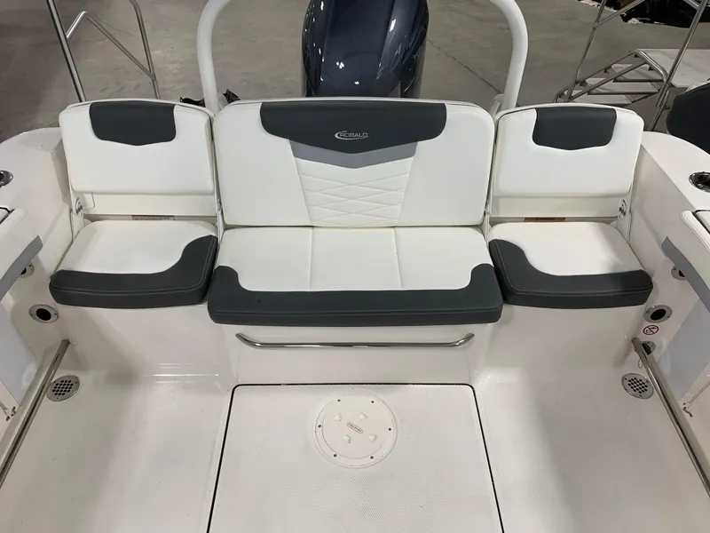 Slide: The Image of 2024 Robalo R207 Dual Console boat seating area with white and gray upholstery. - 12