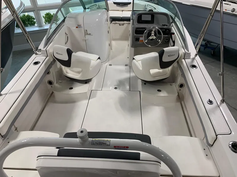 Slide: The Image of 2024 Robalo R207 Dual Console boat interior with white seating and modern dashboard. - 2