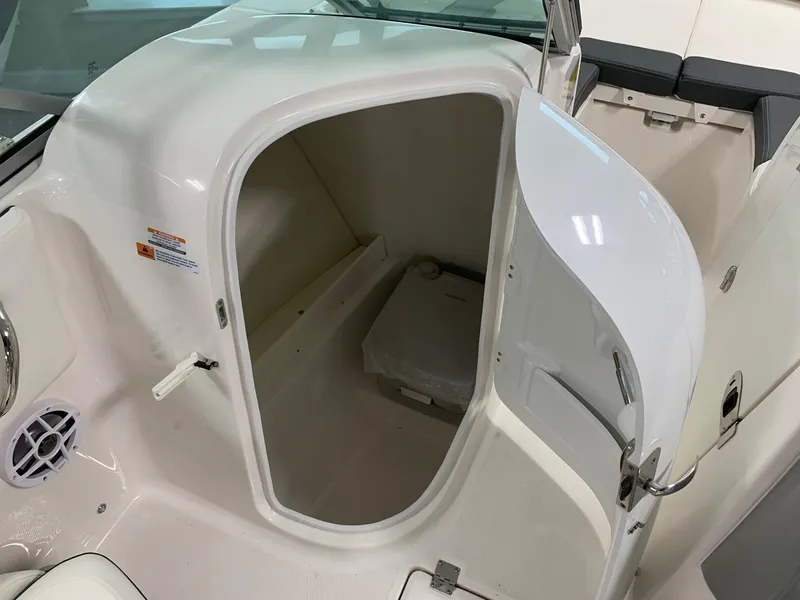 Slide: The Image of 2024 Robalo R207 Dual Console boat storage compartment with open door. - 5