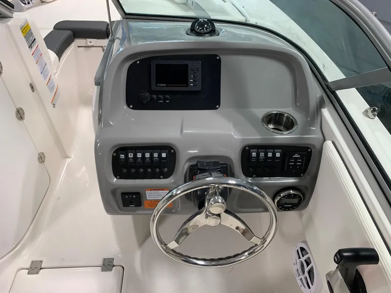 Slide: The Image of 2024 Robalo R207 Dual Console boat dashboard with steering wheel and control panel. - 8