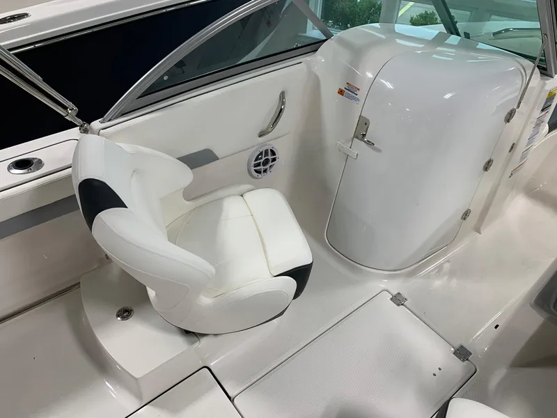 Slide: The Image of 2024 Robalo R207 Dual Console boat interior with white captain's chair and storage compartment. - 9