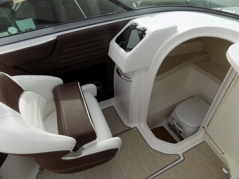 Slide: The Image of 2017 Regal 2500 boat interior with helm seat and compact cabin toilet. - 10