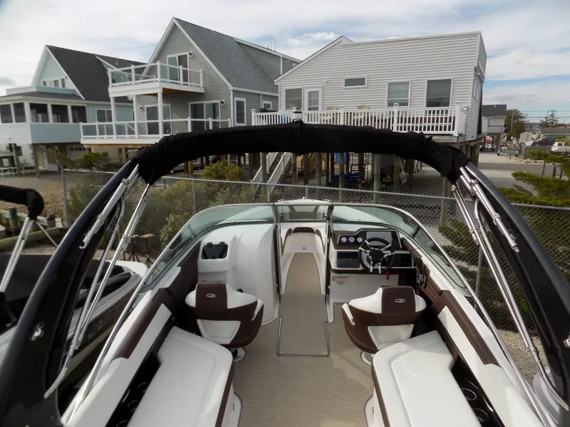 Slide: The Image of 2017 Regal 2500 boat with modern interior, docked near coastal homes. - 11