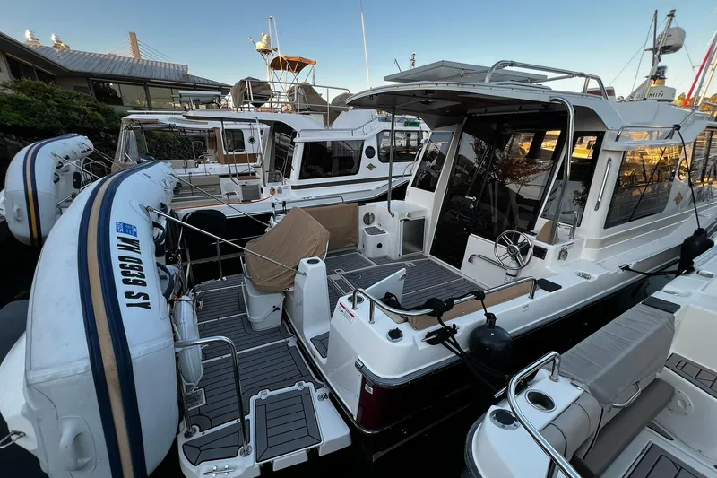 Slide: The Image of 2021 Ranger Tugs R-29S docked, featuring spacious deck and inflatable dinghy. - 1