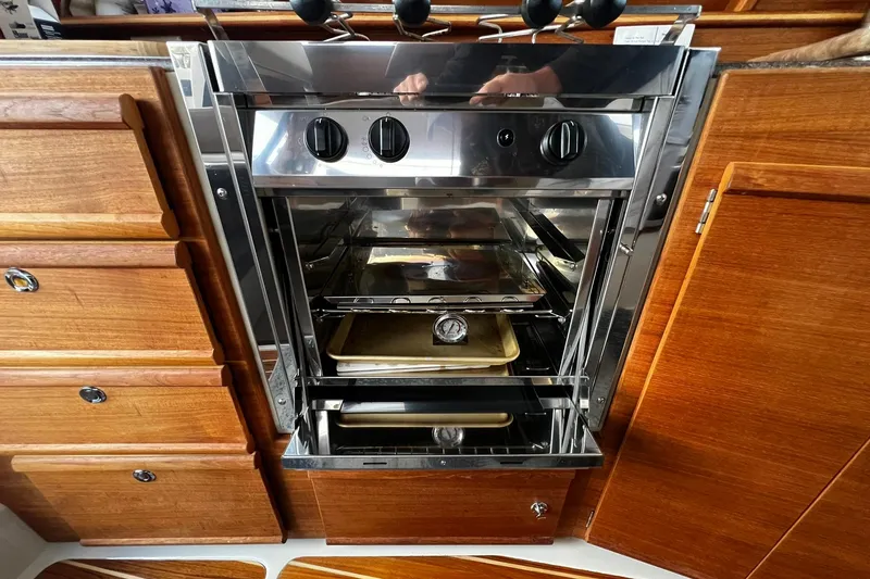 Slide: The Image of Stainless steel oven in 2021 Ranger Tugs R-29S galley with wooden cabinetry. - 15