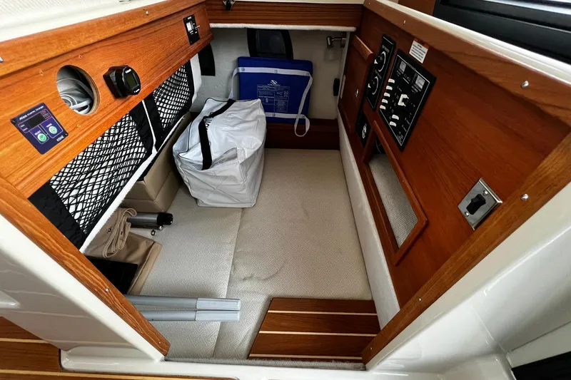 Slide: The Image of 2021 Ranger Tugs R-29S interior cabin with wood paneling and storage compartments. - 6