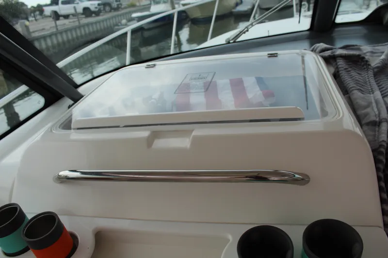 Slide: The Image of Tiara Yachts 3800 Open 2002 model cockpit with storage compartment and cup holders. - 17
