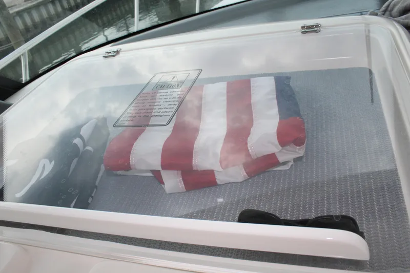 Slide: The Image of Storage compartment on a 2002 Tiara Yachts 3800 Open with a folded American flag. - 18