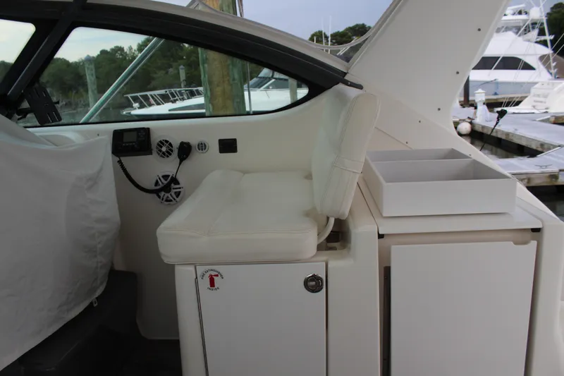 Slide: The Image of 2002 Tiara Yachts 3800 Open helm station with white seating and storage compartments. - 24