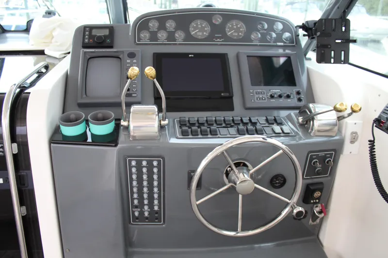 Slide: The Image of 2002 Tiara Yachts 3800 Open helm station with steering wheel and navigation controls. - 25