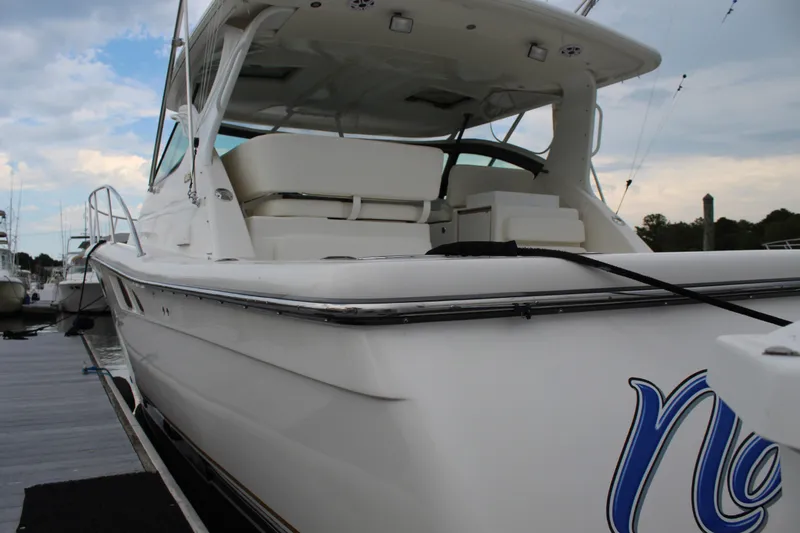 Slide: The Image of 2002 Tiara Yachts 3800 Open docked, showcasing sleek white exterior and spacious seating. - 8