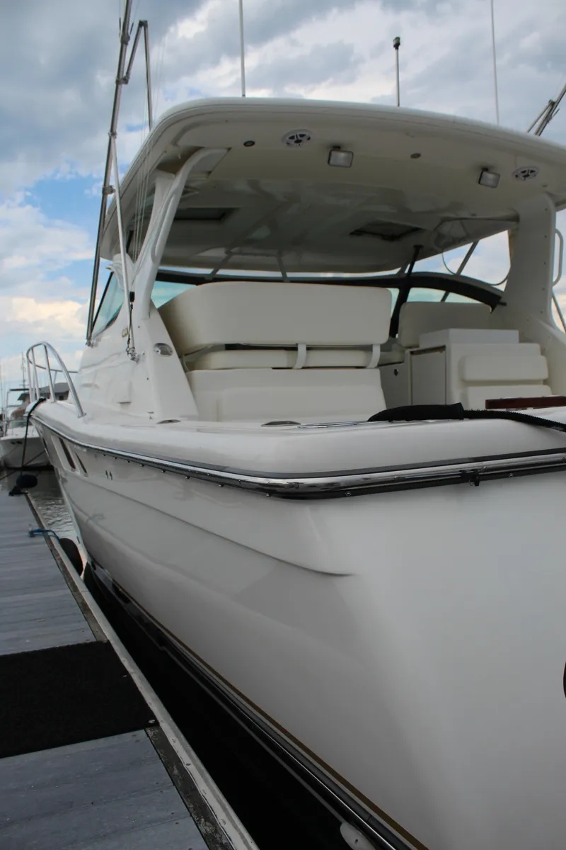 Slide: The Image of 2002 Tiara Yachts 3800 Open docked, showcasing sleek design and spacious deck. - 9