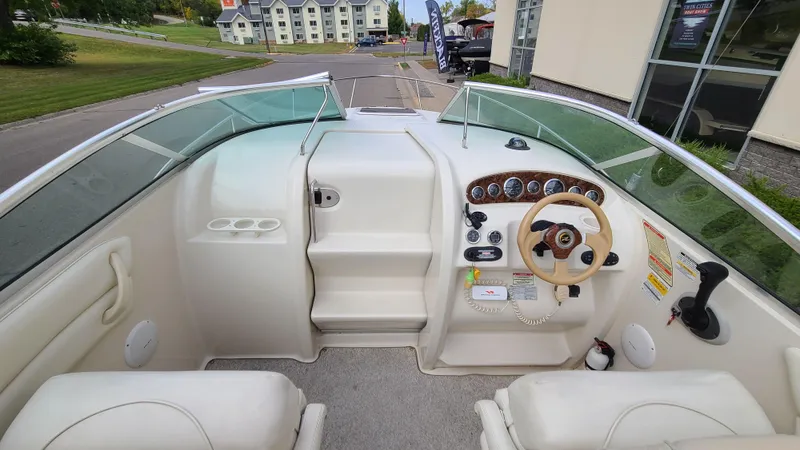 Slide: The Image of 2002 Sea Ray 225 Weekender boat cockpit with steering wheel and control panel. - 13