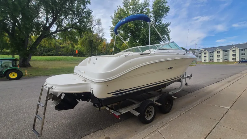 Slide: The Image of 2002 Sea Ray 225 Weekender boat on a trailer with blue bimini top. - 4