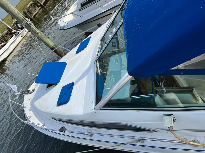 Slide: The Image of 1991 Sea Ray Sundancer 220 boat with blue cushions docked in marina. - 0