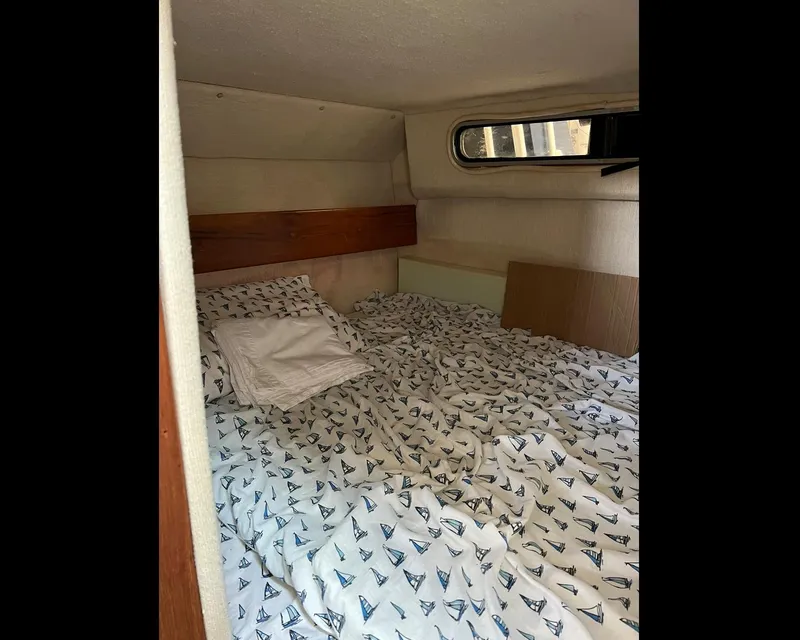 Slide: The Image of Cozy cabin interior of 1991 Sea Ray Sundancer 220 with nautical-themed bedding. - 11