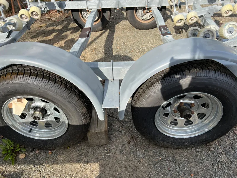 Slide: The Image of Trailer wheels for 1991 Sea Ray Sundancer 220 boat on gravel surface. - 14