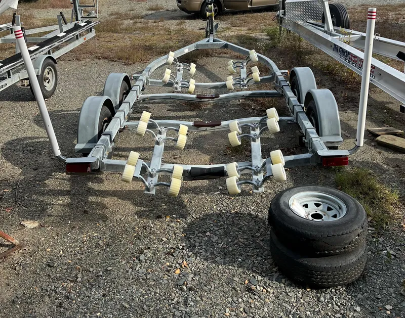 Slide: The Image of Boat trailer for 1991 Sea Ray Sundancer 220, parked on gravel with spare tires. - 16
